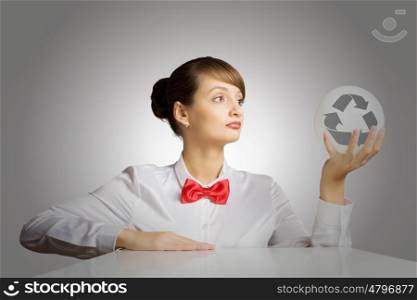 Recycle concept. Young woman holding ball with recycle sign