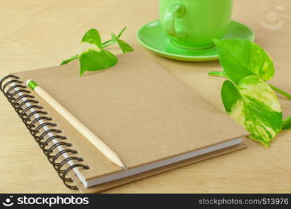 recycle notebook and wooden pencil on wood background