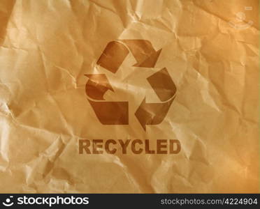 recycle sign on brown crumpled paper.