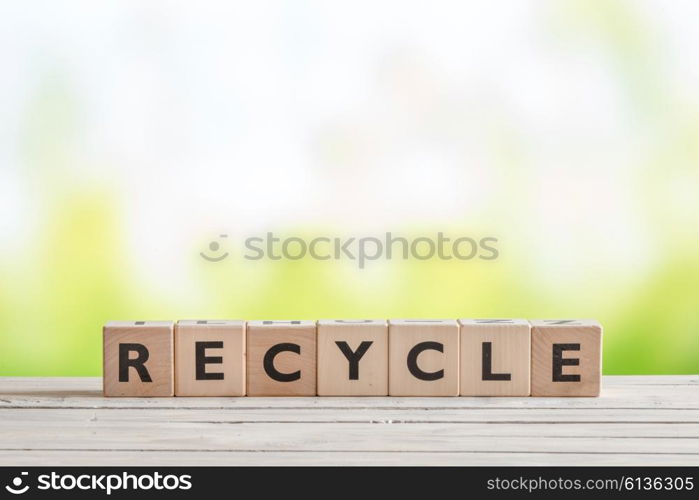 Recycle sign with blocks on a wooden table