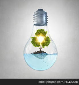 Recycling concept. Glass light bulb with green recycle sign inside