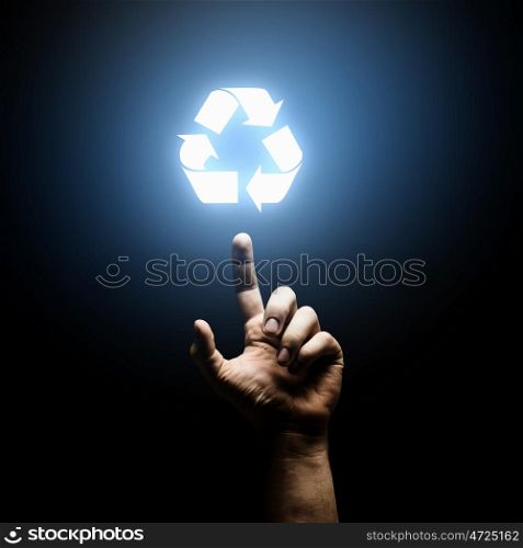 Recycling concept. Human hand pointing with finger at recycle symbol