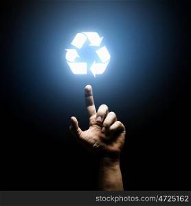 Recycling concept. Human hand pointing with finger at recycle symbol