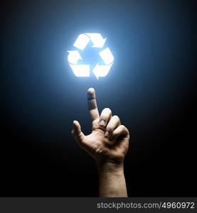 Recycling concept. Human hand pointing with finger at recycle symbol