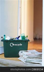 Recycling container and pile of waste paper on floor