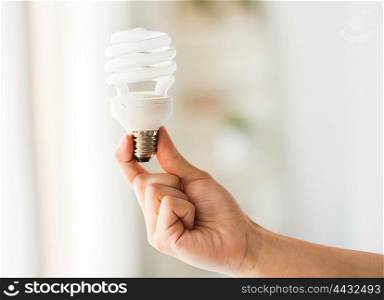 recycling, electricity, environment and ecology concept - close up of hand holding energy saving lightbulb or lamp