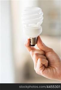 recycling, electricity, environment and ecology concept - close up of hand holding energy saving lightbulb or lamp