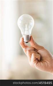 recycling, electricity, idea, environment and ecology concept - close up of hand holding lightbulb or incandescent lamp