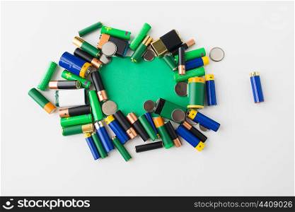 recycling, energy, power, environment and ecology concept - close up of alkaline batteries and green blank copy space