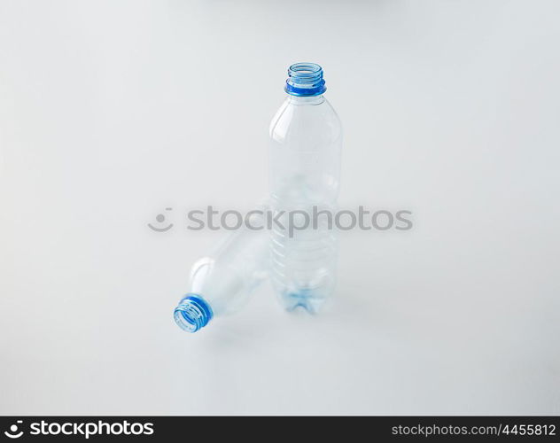 recycling, healthy eating and food storage concept - close up of clean empty used plastic water bottles on table