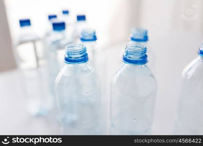 recycling, healthy eating and food storage concept - close up of empty plastic water bottles on table