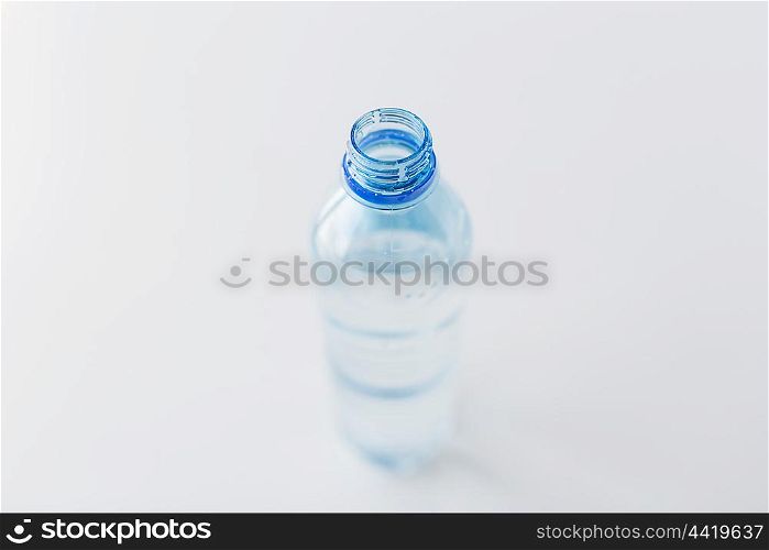 recycling, healthy eating and food storage concept - close up of open plastic bottle with pure drinking water on table