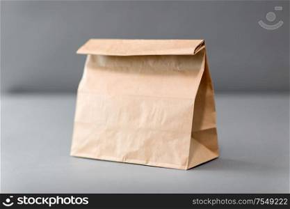 recycling, reuse and ecology concept - disposable brown takeaway food in paper bag with lunch on table. takeaway food in paper bag with lunch
