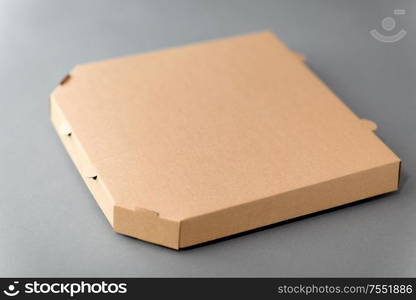 recycling, reuse and ecology concept - disposable brown takeaway food or pizza in brown paper box on grey background. takeaway food or pizza in brown paper box