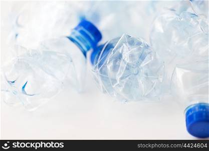 recycling, reuse, garbage disposal, environment and ecology concept - close up of empty used crashed plastic water bottles on table