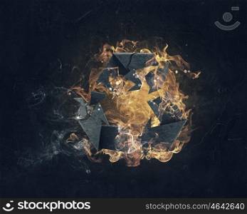 Recycling symbol in fire. Recycle sign in fire flames on dark background