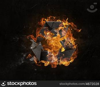 Recycling symbol in fire. Recycle sign in fire flames on dark background