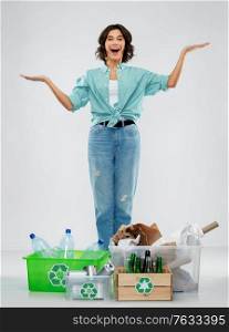 recycling, waste sorting and sustainability concept - happy smiling young woman with plastic and glass bottles, paper and metal tin cans in boxes over grey background. happy woman sorting paper, metal and plastic waste