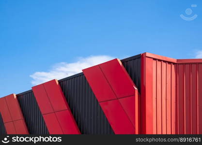 Red and black aluminum composite tile and Corrugated steel on exterior Modern Building wall in industrial style against blue sky, low angle and perspective side view