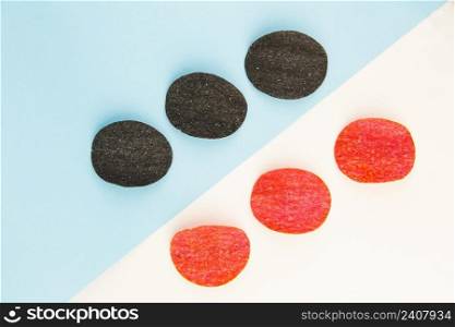 Red and black potato chips with salt, chili pepper. Isometric drawing. Chips background on white and blue background. Red and black potato chips with salt, chili pepper. Isometric drawing. Chips background on white and blue background.