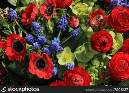 Red and blue spring flower arrangement: anemones, ranunculus and grape hyacints