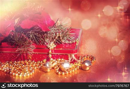 Red and Gold Christmas Decoration of Poinsettia, Bells, Beads and Box on Defocused Lights Background