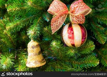 red and golden ball with bow and bell on christmas tree
