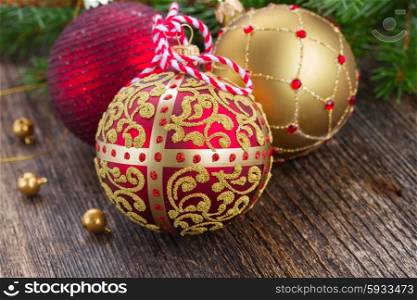 red and golden christmas balls close up on wooden background. red and golden christmas balls