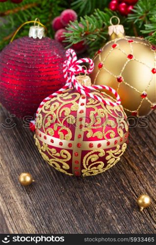 red and golden christmas balls on wooden background. red and golden christmas balls