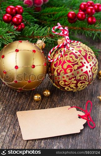 red and golden christmas balls . red and golden christmas balls on wood with empty tag