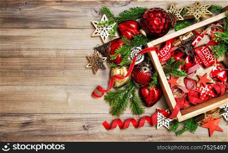 Red and golden Christmas decorations and ornaments on rustic wooden background