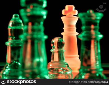 red and green glass chess pieces is standing on board in dark