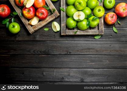 Red and green juicy apples in wooden boxes. On wooden background.. Red and green juicy apples in wooden boxes.