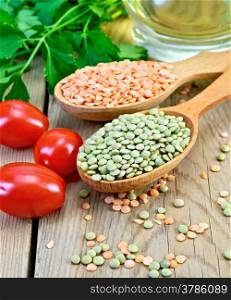 Red and green lentils in a wooden spoon, tomatoes, parsley, vegetable oil in a decanter on a wooden board
