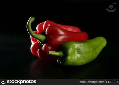 Red and green pepper over black