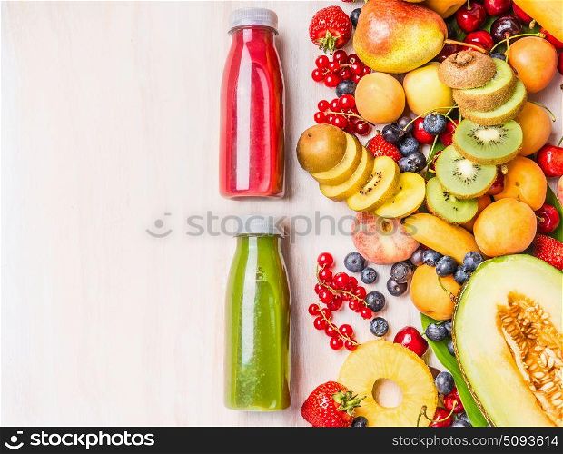 Red and green smoothies and juices beverages in bottles with various fresh organic fruits and berries ingredients on white wooden background, top view. Healthy food and vegetarian concept