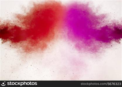 Red and pink Holi colors splashing over white background