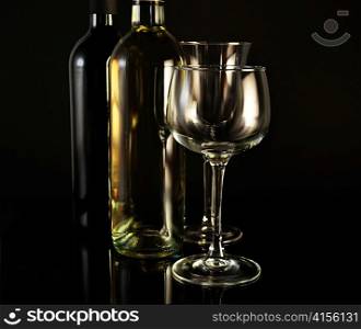 red and white bottles of wine on black background