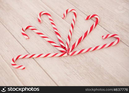 Red and white candy canes on a gray wooden background