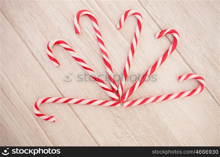 Red and white candy canes on a gray wooden background