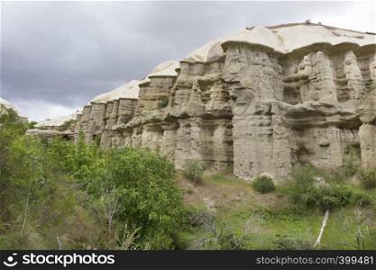 Red and white sandstone cliffs, ancient caves in a mountain landscape between valleys in Cappadocia, central Turkey. Mountain Honey and Red valleys in Cappadocia