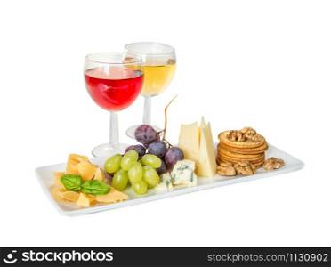 Red and white wine, different varieties of cheese, grapes and basil leaves on the white porcelain plate isolated on a white background
