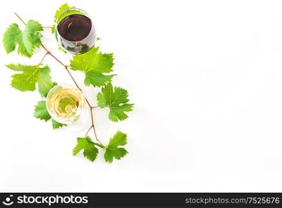 Red and white wine glasses with green leaves on white background