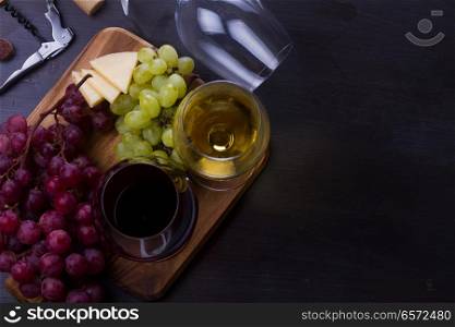 Red and wite wine in glasses with grape fruit, top view, copy space on wooden table. Glass of red and white wine