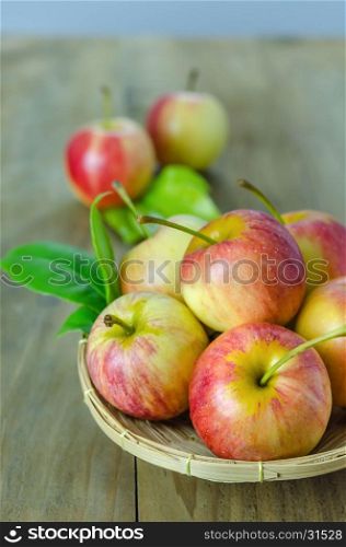 Red and yellow apple with bamboo basket , organic fresh fruit on white wooden background