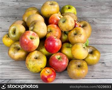 red and yellow organic apples on a wooden table