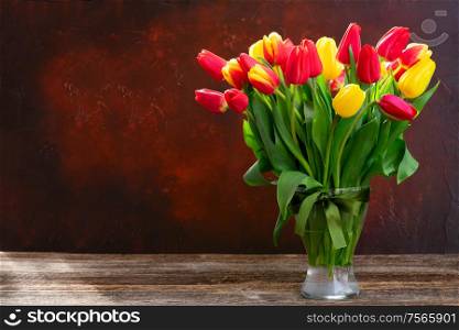 red and yellow tulips fresh flowers on dark background with copy space. red and yellow tulips