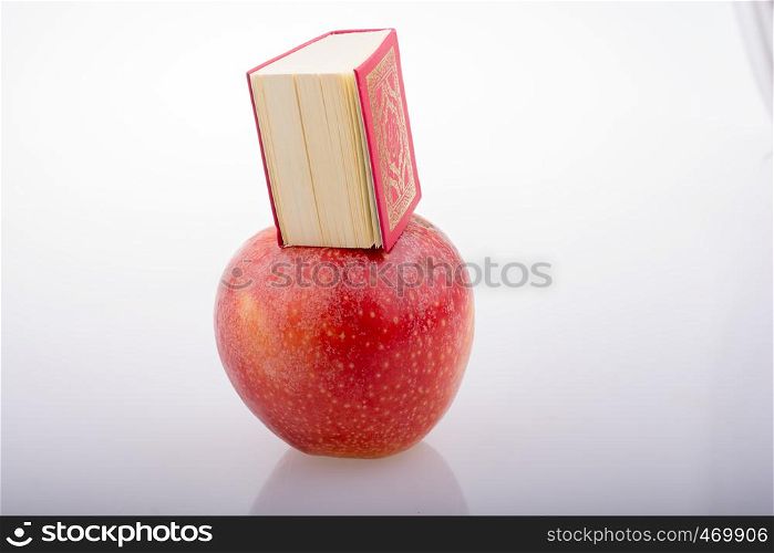 Red apple and Islamic Holy Book Quran in mini size