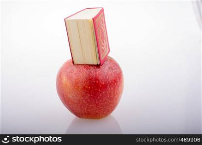 Red apple and Islamic Holy Book Quran in mini size