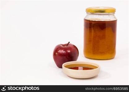 Red apple and jar of honey bowl of honey isolated on a white background. Symbols of Jewish New Year - Rosh Hashanah.